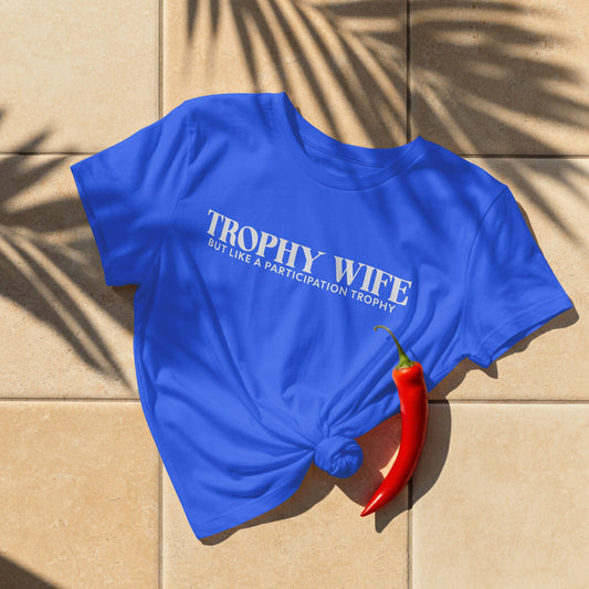 Blue t-shirt with 'Trophy Wife' text on a beige surface with a red chili pepper.